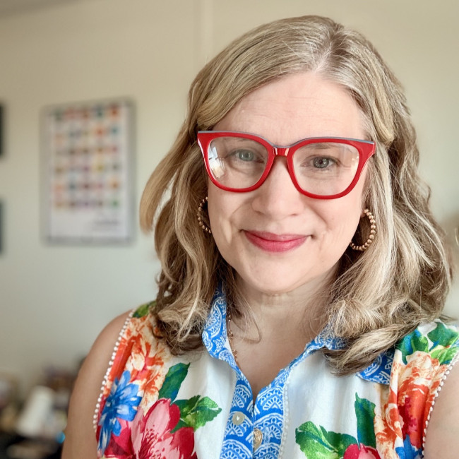 woman smiling with red glasses